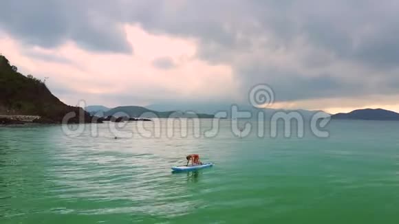 扎着马尾辫的女孩站在海洋桨板上摆姿势视频的预览图