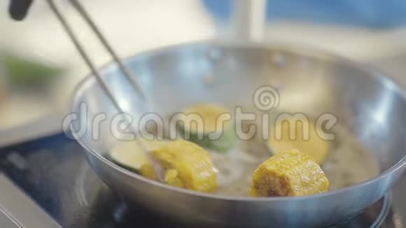 厨师炊具黑色手套风琴或炖片西葫芦和玉米在一个热锅与油快关门视频的预览图