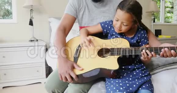 爸爸和女儿在卧室里弹吉他视频的预览图