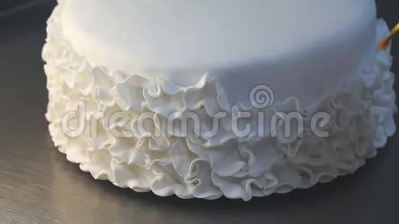 用糖碎花装饰白色结婚蛋糕视频的预览图