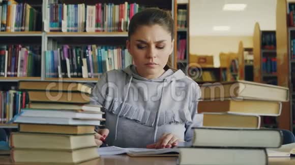 在大学项目工作期间集中年轻女学生阅读书籍和在笔记本上写作视频的预览图