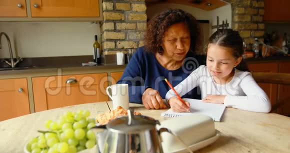 祖母在厨房帮助孙女学习视频的预览图