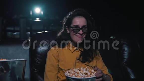 女孩笑着在电影院吃爆米花视频的预览图