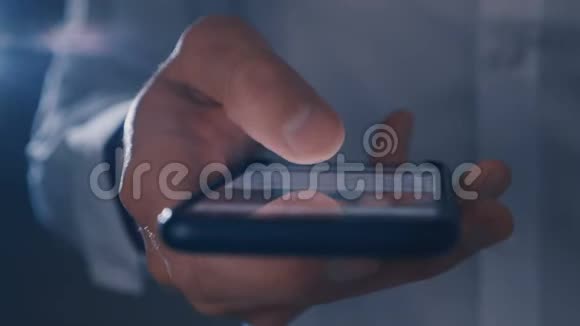 晚上雄性手在黑色的大智能手机上滚动新闻线视频的预览图