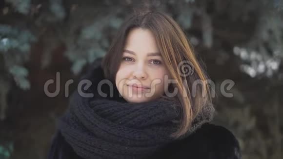 冬季云杉背景下户外女子特写年轻貌美的女人长着棕色的眼睛和微笑视频的预览图