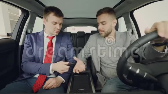 汽车经销商正把钥匙给热情的男性买家男人在里面握手微笑和交谈视频的预览图