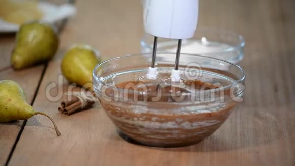 巧克力面团在玻璃碗中与搅拌机混合做巧克力梨蛋糕视频的预览图