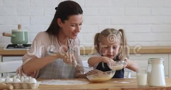 可爱的小女儿在厨房帮妈妈准备面团视频的预览图