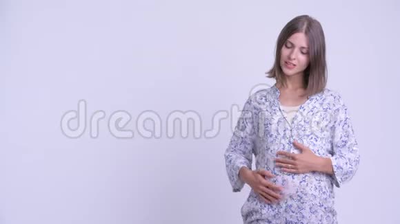 快乐的年轻孕妇说话展示一些东西视频的预览图