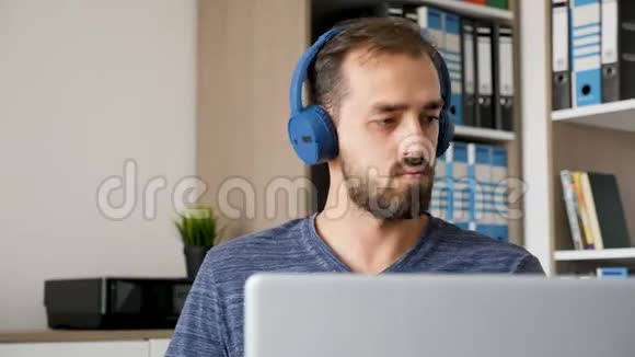 有创意的留胡子的人一边工作一边听音乐视频的预览图