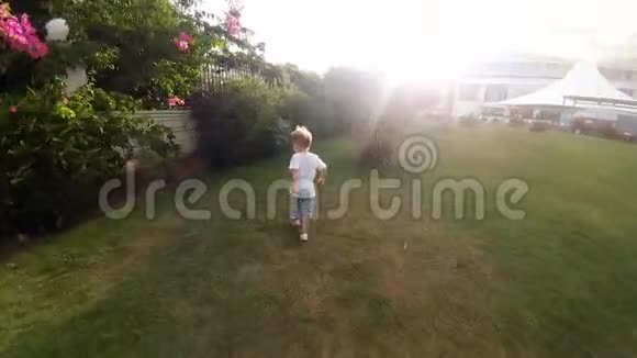 在热带花园的树林间奔跑的快乐欢笑幼儿男孩4k视频视频的预览图
