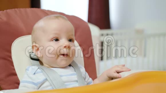 可爱的宝宝在家里的椅子上吃饭视频的预览图