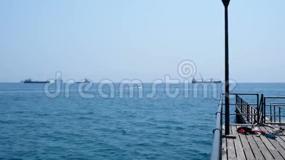 在晴朗的一天拍摄了公海蓝天码头远处的船只和无边无际的地平线视频的预览图