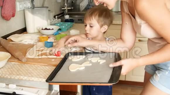 4k小男孩和妈妈一起用面团做饼干然后放在烤片上视频的预览图