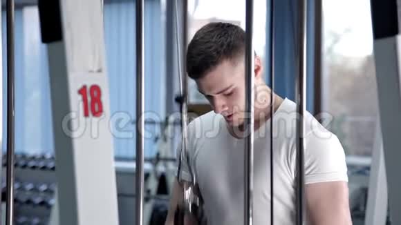 健身房里的一个男人抖他的三头肌视频的预览图