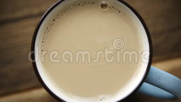 把糖从勺子里倒入一杯牛奶咖啡视频的预览图