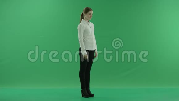 在绿色背景前滚动通过虚拟显示器的商务女性她穿着正装白衬衫视频的预览图