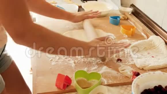 特写4k小女子在大木制烹饪板上擀面团的镜头视频的预览图