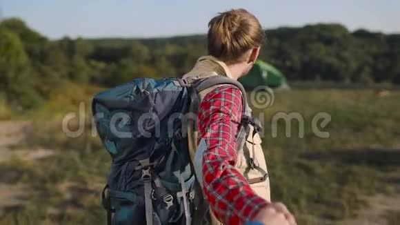 英俊的旅游男子在大自然中旅行牵着女人手视频的预览图