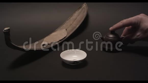 将中国茶从传统的宜兴陶壶中倒入一杯视频的预览图