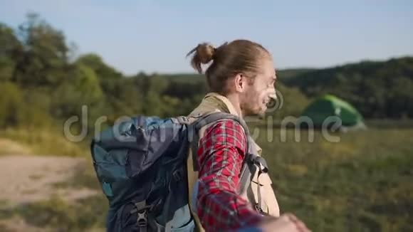 英俊的旅游男子在大自然中旅行牵着女人手视频的预览图