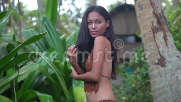 丛林中慢动作的亚洲模特年轻的长发黑发女郎在户外摆姿势视频的预览图