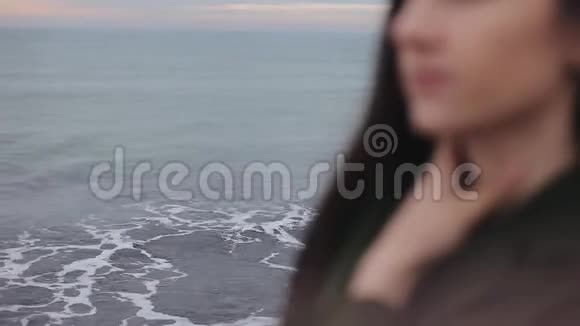 日出时美丽的大海一个年轻女孩的视线模糊左手搭在脖子上焦点从视频的预览图