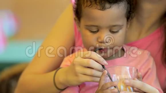 特写小女儿在一家咖啡馆吃饭妈妈女儿喝柠檬水视频的预览图