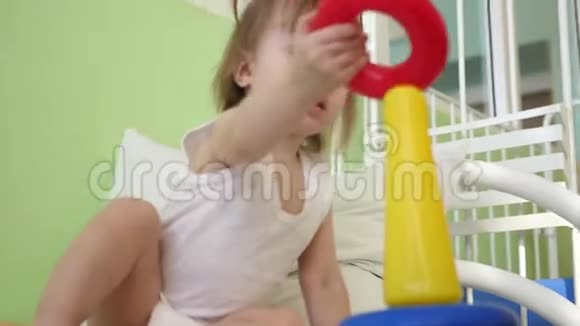 小宝宝坐在医院病房的床上玩金字塔生病的女孩在医院里康复视频的预览图