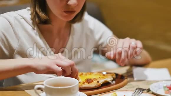 女人在一家有白种人美食的餐馆吃午饭特写镜头女人吃热汁多的卡查普里蘸一块视频的预览图