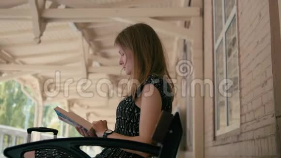 女青年在铁路车站用套装阅读一本书视频的预览图