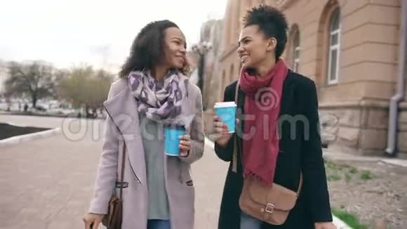 两个美丽的混血女朋友在购物和步行后喝咖啡和交谈视频的预览图
