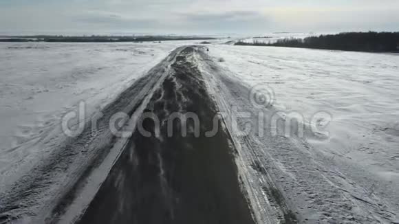 无人机飞过冬路风吹雪过马路寒冷的天气视频的预览图