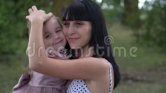 美丽的年轻母亲抱着女儿拥抱和温柔慢动作视频的预览图