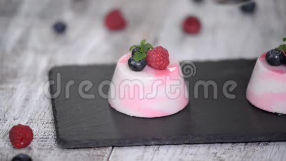 美味的浆果慕斯甜点以新鲜的覆盆子蓝莓和薄荷装饰视频的预览图
