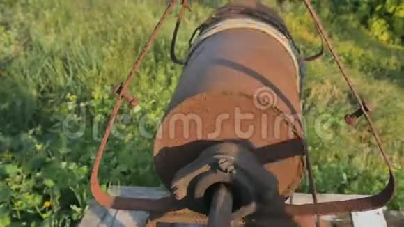 女人用水桶把链条滴到乡村井里打水老式水井连锁关闭旧的生锈的链子视频的预览图