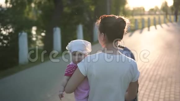 妈妈手牵着宝宝走在公园路上慢镜头阳光明媚视频的预览图