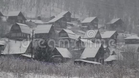 村庄降雪小农舍和树被雪覆盖视频的预览图