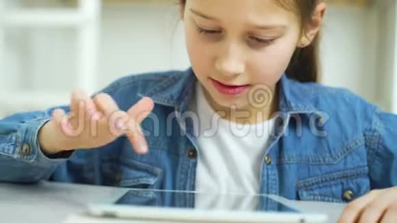 小女孩在平板电脑上玩网络游戏特写视频的预览图