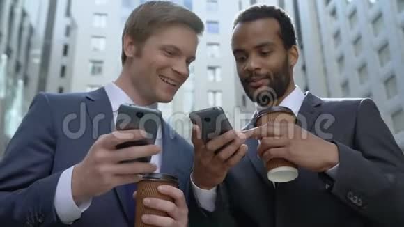 快乐的商人在智能手机上使用轻松的移动应用程序同事在午休时使用视频的预览图