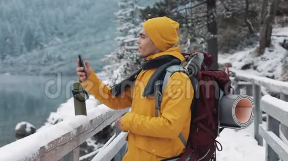 寒假里有视频聊天的年轻人Hiker在手机摄像头旁边挥舞着摄像头视频的预览图