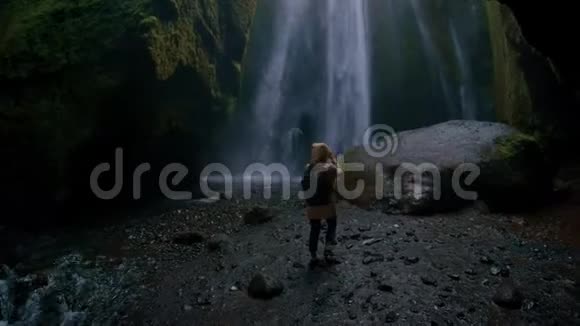 年轻的旅行博客写手带瀑布的史诗洞视频的预览图