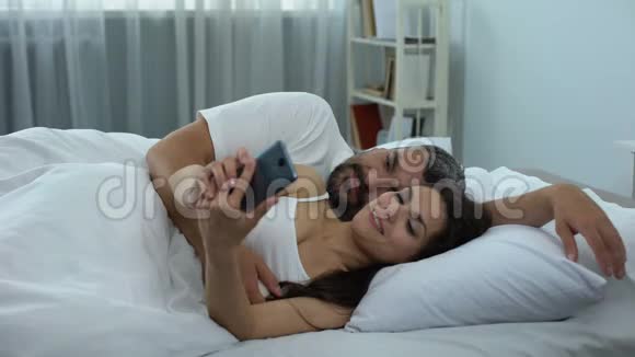 快乐夫妻在床上自拍第一张照片作为夫妻家庭视频的预览图