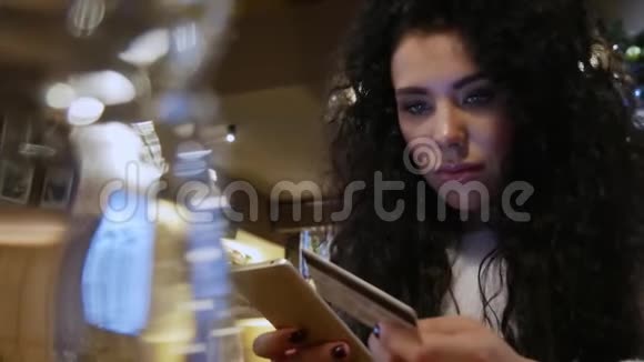 美丽的女孩留着卷发在餐馆里网上购物视频的预览图