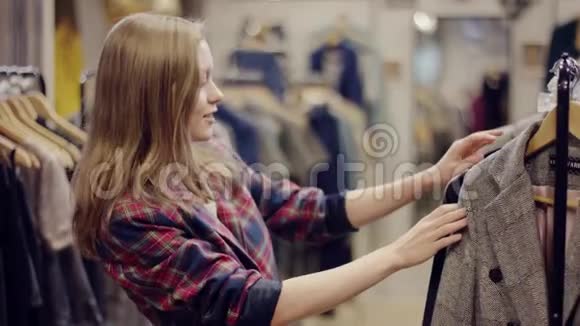 在服装店里找衣服的迷人年轻女人视频的预览图