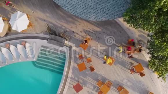 热带岛屿上舒适的度假胜地美丽的游泳池和带雨伞的日光浴床视频的预览图