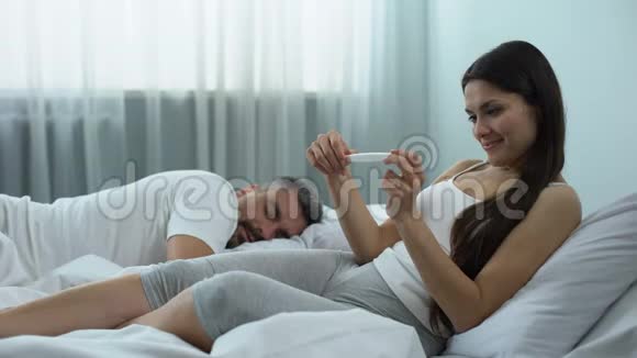 快乐的女人唤醒丈夫讲述怀孕计划生育视频的预览图