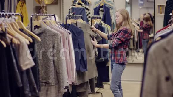 成年美女在智能手机摄像头上的服装店拍照视频的预览图