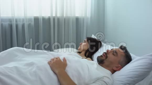 男人在床上打鼾妻子醒了推着丈夫健康问题视频的预览图