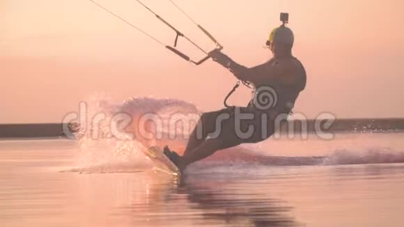 一个戴着照相机头盔的人在日落时在湖上表演特技动作缓慢视频的预览图